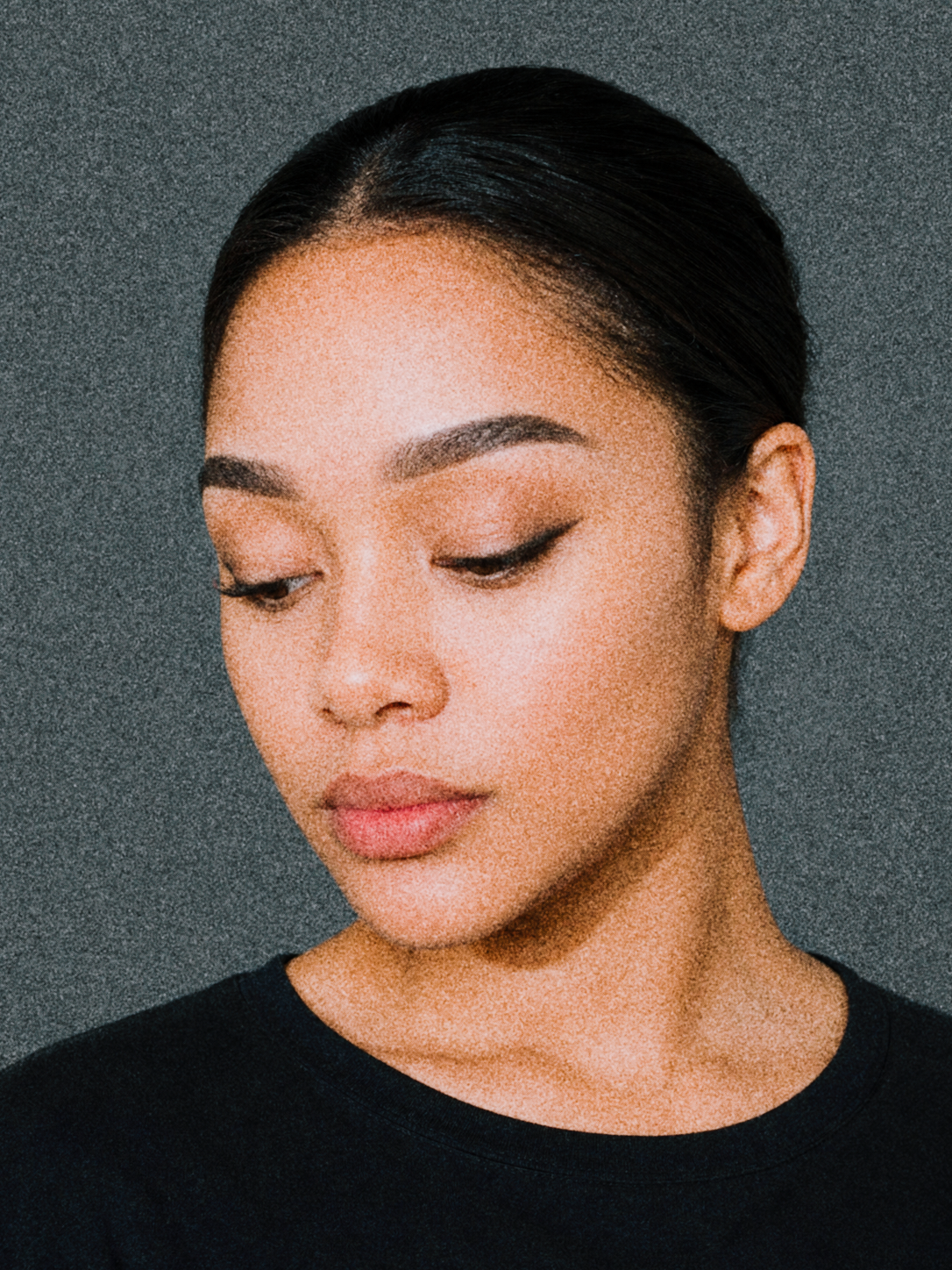Portrait of Refilwe Modibedi looking downward against a dark neutral background.